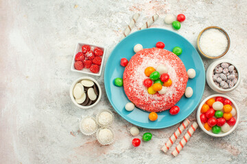 top view delicious pink cake with colorful candies on the white background rainbow color dessert cake candy