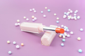 A Red color beautiful lipsticks with decoration on purple  background.