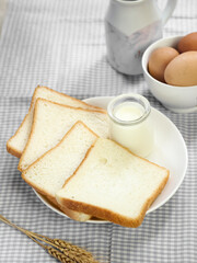 Sliced Toast Loaf White Bread (Shokupan or Roti Tawar) for Breakfast on Wooden Background, Served with Egg and Milk. Breakfast Concept Picture