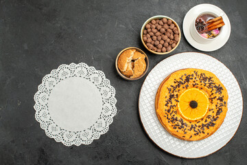 Obraz na płótnie Canvas top view delicious sweet pie with cup of tea on dark background cookies pie biscuit dessert tea cake