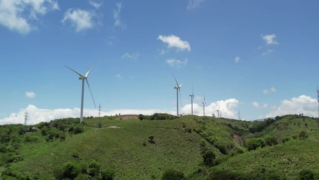 wind turbine on the hill in dominican republic using drone footage tilt up technique
