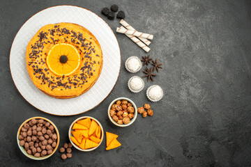 Obraz na płótnie Canvas top view delicious sweet pie with orange slices on dark-grey background fruit pie cake dough biscuit