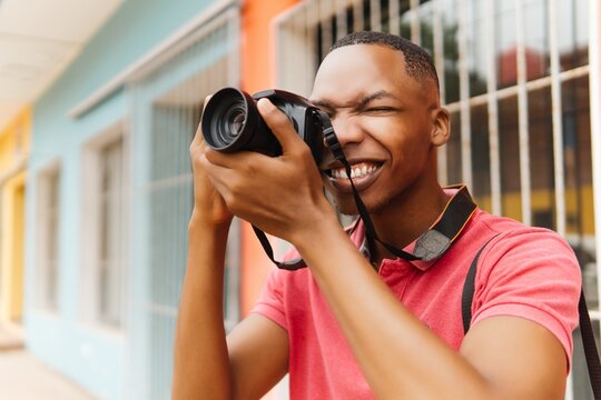 Young stylish male photographer using camera while exploring the city. Photographer world day concept. - Powered by Adobe