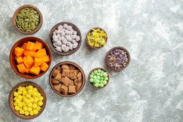 top view different candies with seeds and flowers on white background flower color candy tea