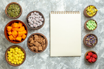 top view different candies with seeds and pumpkin on a white background flower color candy tea