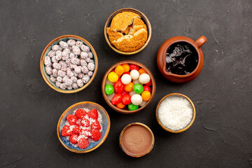 top view different colorful candies with confitures on dark background color cookie candy tea biscuit