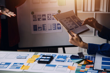Close up ux developer and ui designer brainstorming about mobile app interface wireframe design on...