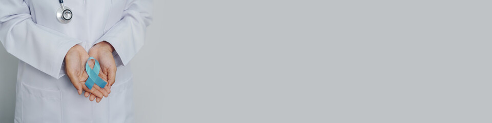 Doctor asian female specialist holding blue ribbon and stethoscope and Breast cancer awareness concept