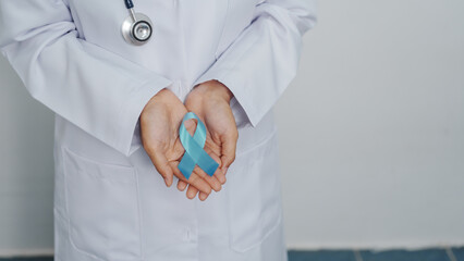 Doctor asian female specialist holding blue ribbon and stethoscope and Breast cancer awareness concept