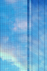 Obraz premium Reflection of sky and clouds in glass wall of high-rise building. Glass wall of skyscraper. Mirrored wall of high-rise building