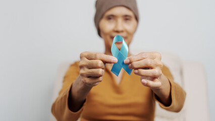 Mature woman suffering from cancer, asian people, 70s years old with head scarf, blue ribbon, elderly National Cancer Awareness Day concept.