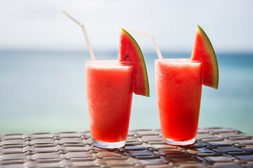 Two fresh watermelon juices on a tropical beach
