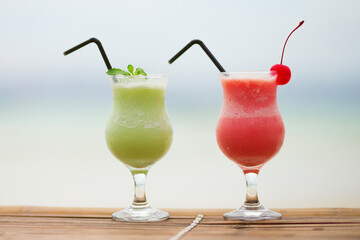 Two fresh fruit juices on a tropical beach