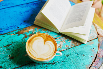 Fresh coffee and book on a wooden table
