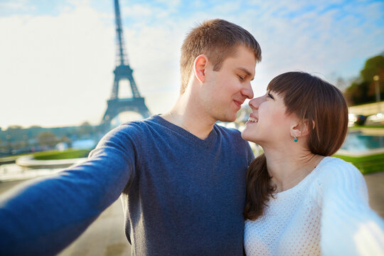 Happy couple of tourists taking selfie in Paris