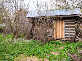wooden shed on backyard in village on cloudy spring day