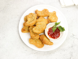 Fried crispy chicken nuggets with tomato sauces served in white plate
