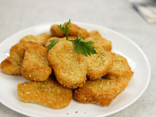Fried crispy chicken nuggets with tomato sauces served in white plate
