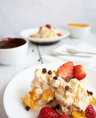 
Ice cream with strawberries and chocolate drizzle. On a wooden background. Dessert