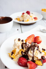 
Ice cream with strawberries and chocolate drizzle. On a wooden background. Dessert