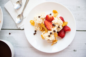 
Ice cream with strawberries and chocolate drizzle. On a wooden background. Dessert