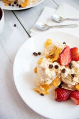 
Ice cream with strawberries and chocolate drizzle. On a wooden background. Dessert