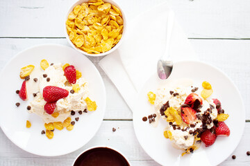 
Ice cream with strawberries and chocolate drizzle. On a wooden background. Dessert