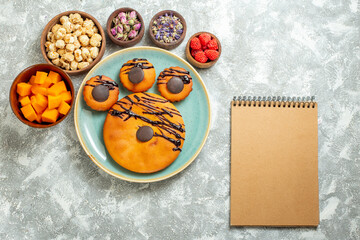 top view yummy cocoa cakes with chocolate icing and flowers on a white background biscuit sweet cake dessert cookie pie