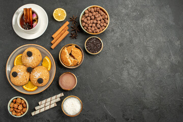 Obraz na płótnie Canvas top view yummy cookies with cup of tea on dark background cake pie sugar dessert biscuit tea
