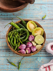 Ingredients for making Sambel Ijo, a typical chili sauce from Padang, West Sumatra consisting of green chilies, green tomatoes, shallots, garlic and a little lime juice