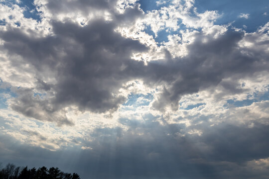 Looking up at gray clouds with silver lining against blue sky