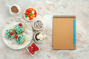 top view yummy little cakes with colorful candies on white background dessert cake pie rainbow color candy