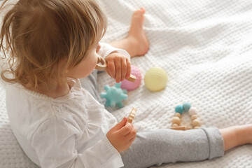 Obraz na płótnie Canvas Cute baby girl playing tactile knobby balls. Young child hand plays sensory massage ball. Enhance the cognitive, physical process. Brain development. Support for Children with ADHD, autism, fidgeting