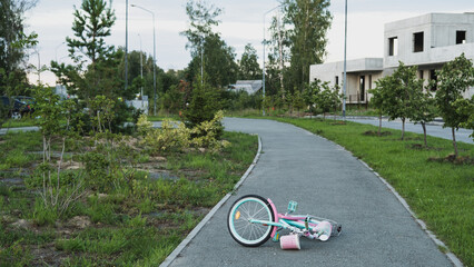 Lonely children's bicycle lying on the road. Summer time
