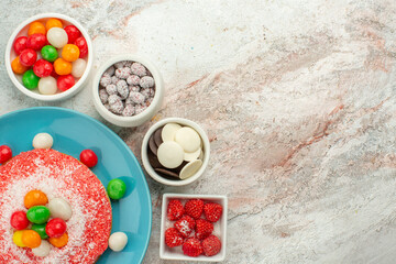 top view yummy pink cake with colorful candies and cookies on white background dessert pie rainbow color cake candy