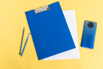 A blue stationery set as a template with a place to copy on a yellow background with a blue phone.