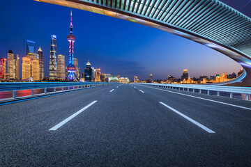 Fototapeta na wymiar Straight asphalt road and city skyline with modern buildings in Shanghai, China.