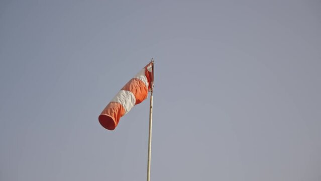 Striped windsock at the background of overcast sky