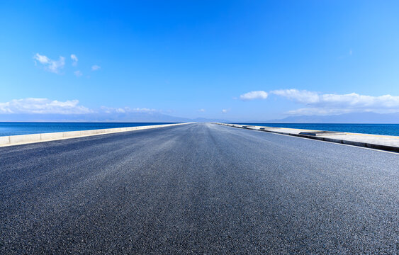 Asphalt road and lake with sky cloud background