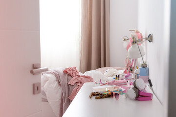 an open door to a teenager's room, which is a mess. Pink things, girl's room