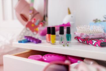 mess in the little girl's room. Nightstand with pink accessories close-up