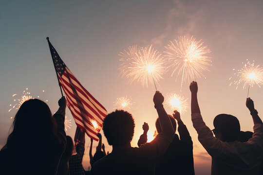 Silhouette of a group of people from the United States celebrating with flags and sparklers on Independence Day, July 4th. USA