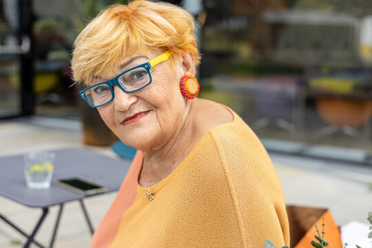 Close up portrait of a mature 80 years old smiling woman in glasses 