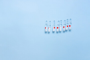 Flat lay medicine ampoules on a blue background. Vaccination. Medicine.