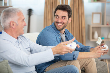 overjoyed excited two generations men family playing video-game