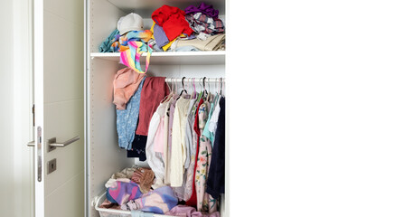 close-up, a chest of drawers from which colored clothes fall out, a mess