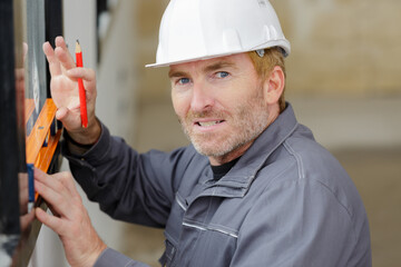 a man is measuring windows