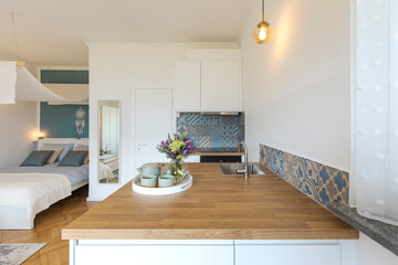 Studio with one double bed, one single bed. There is also a small white kitchen