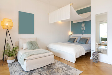 Studio apartment with one double bed and one single bed. There is also parquet flooring, a lamp and a nice canopy.