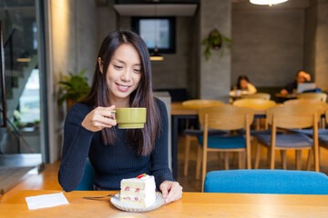 Woman enjoy her cake in coffee shop